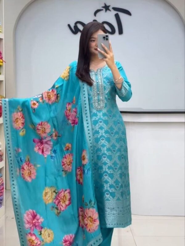 "Turquoise Chanderi silk suit set featuring a geometric jacquard kurta with embroidered neckline and a contrasting floral print silk dupatta."